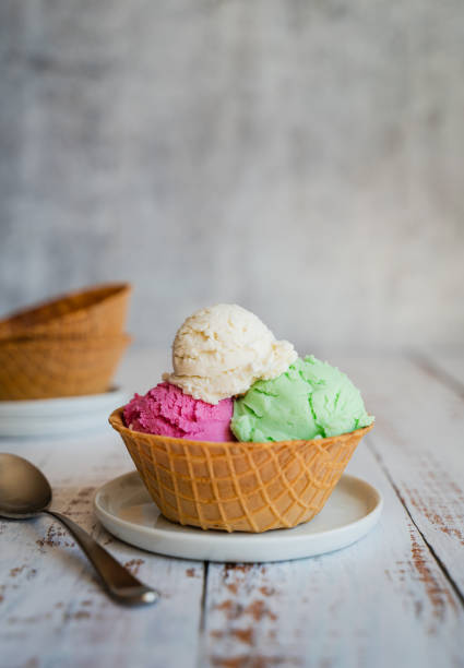 istock Three scoops of ice cream in a waffle bowl on weathered wood table. 1638780167