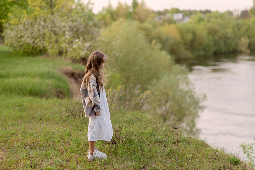 A happy little girl walks in nature. The child is exploring nature. in Belarus, Mogilev Region, Belarus