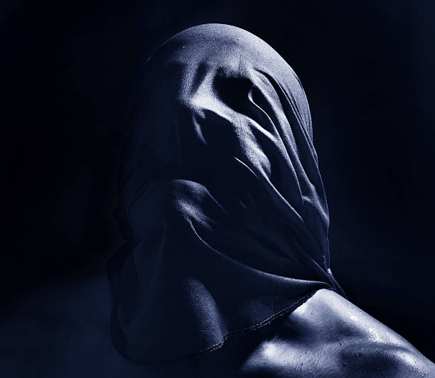 man with cloth over face creating scary look or suffocation