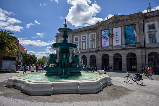 Fountain of the Lions in front of University of Porto in Gomes Teixeira Square, Porto, Portugal. A few people and a bike can be seen.