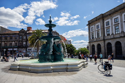 Fountain of the Lions in front of University of Porto in Gomes Teixeira Square, Porto, Portugal. A few people and a bike can be seen.