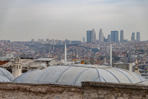 A picture of the buildings of the Beyoglu and Sisli districts seen above the domes of the Suleymaniye Salis Madrasa.