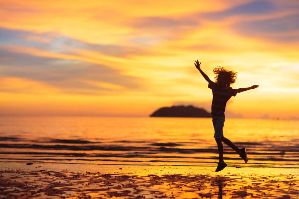istock Child playing on ocean beach. Kid at sunset sea. 1638840167