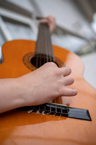 istock Unrecognizable person playing acoustic guitar near wall 1638861445