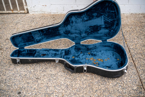 High angle of modern standard molded guitar case with inside blue liner placed on marble tiled floor near wall with fence while latches hinges and handle in good condition