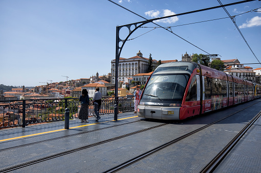 Metro train on Dom Luis I bridge over Douro river, Porto, Portugal. Colorful buildings at the old district of Ribeira in the background.