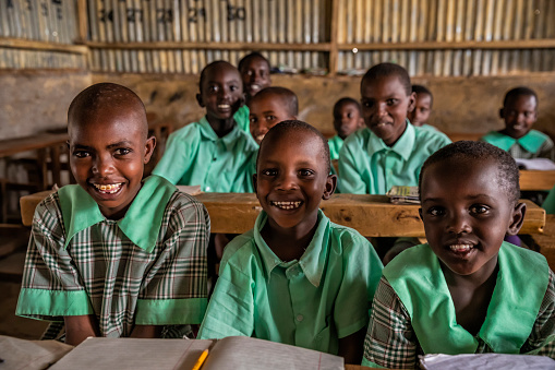 Four gorgeous African Black Children Sitting in Desks. Candid picture of African children in a School Building.