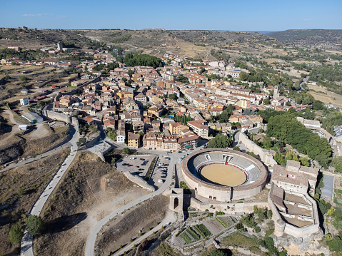 aerial image of the village of Brihuega in the province of Guadalajara Spain, with the bullring La Muralla in the foreground and its wall surrounding the village horizontal