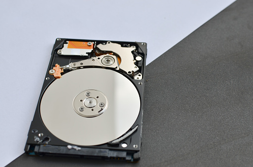 Closeup of a laptop hard disk on a surface, conveying the idea of technical assistance and innovation.