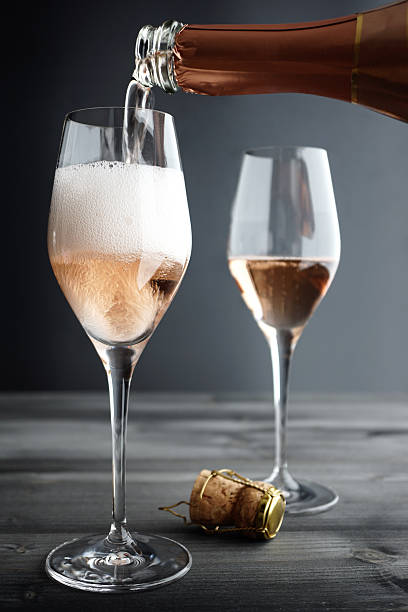 champagne rosé être rempli en verre - pink champagne photos et images de collection