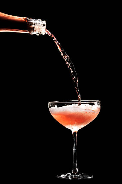 Rosé Champagne being filled in coupe glass stock photo