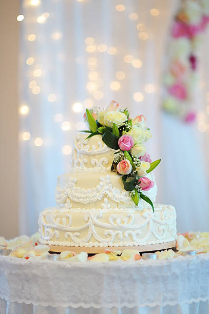 istock White wedding cake topped with flowers on a table 163896055