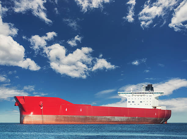 Anchored Oil Tanker A massive oil tanker is anchored in a still harbour under sunny skies. oil tanker stock pictures, royalty-free photos & images