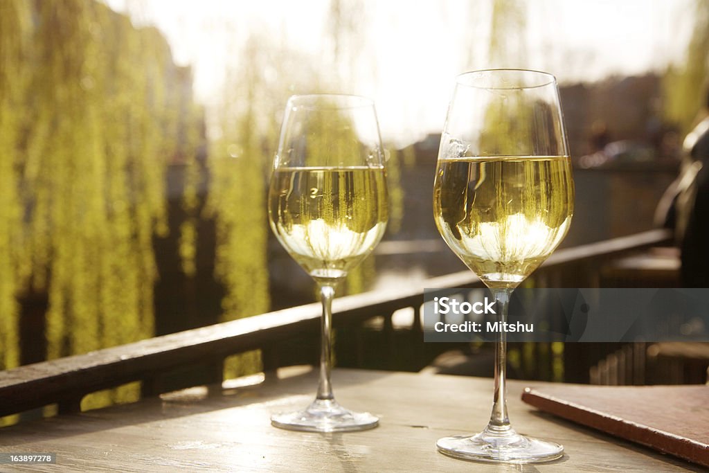 Dos vasos de vino blanco contra la luz del - Foto de stock de Vino blanco libre de derechos