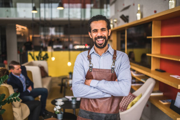 istock Cheerful Middle Easter Waiter With Arms Crossed In A Coffee House 1639024509