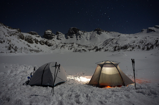 Two tents on snow in front of frozen lake, Lac d'Allos, France