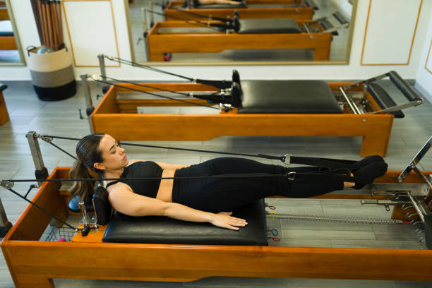 istock Young latin woman at a bed reformer pilates class 1639025713