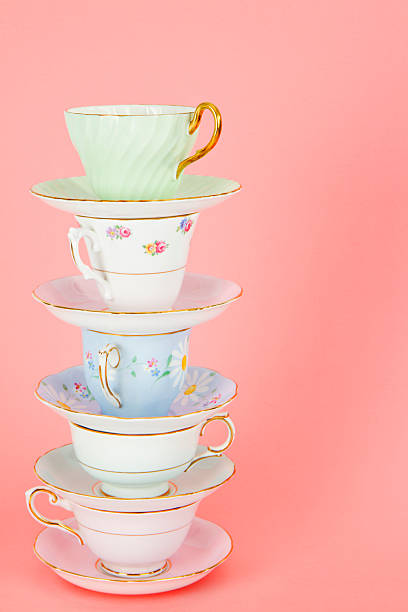 istock Four Pretty Old Fashioned Antique Teacups Stacked On Pink 163907186