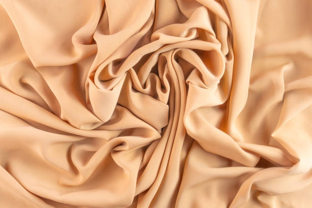 istock Abstract silk background peach fabric fancy liquid waves 1639095686