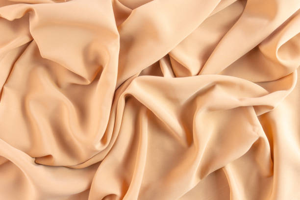 istock Abstract silk background peach fabric fancy liquid waves 1639095690