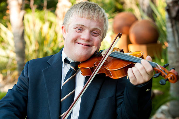 uśmiech niepełnosprawnych chłopiec bawi się jego skrzypce. - child outdoors bow horizontal zdjęcia i obrazy z banku zdjęć