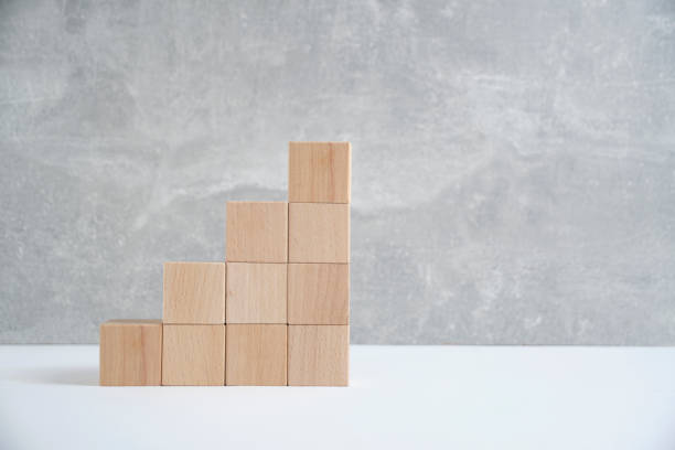 istock Steps made of wooden cubes light concrete background.Empty space for text. 1639111584