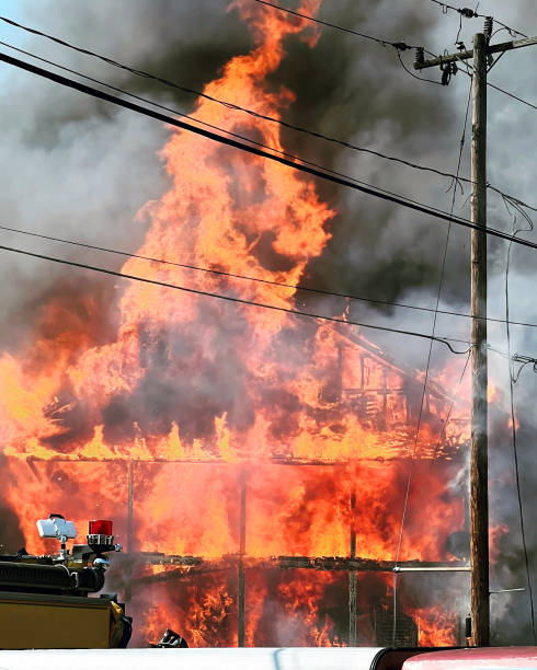 istock Raging House Fire with Thick Smoke Partial Firetruck in Foreground 1639120942