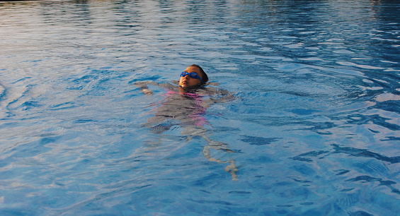 Indonesian teenage girl relaxing in the swimming pool.