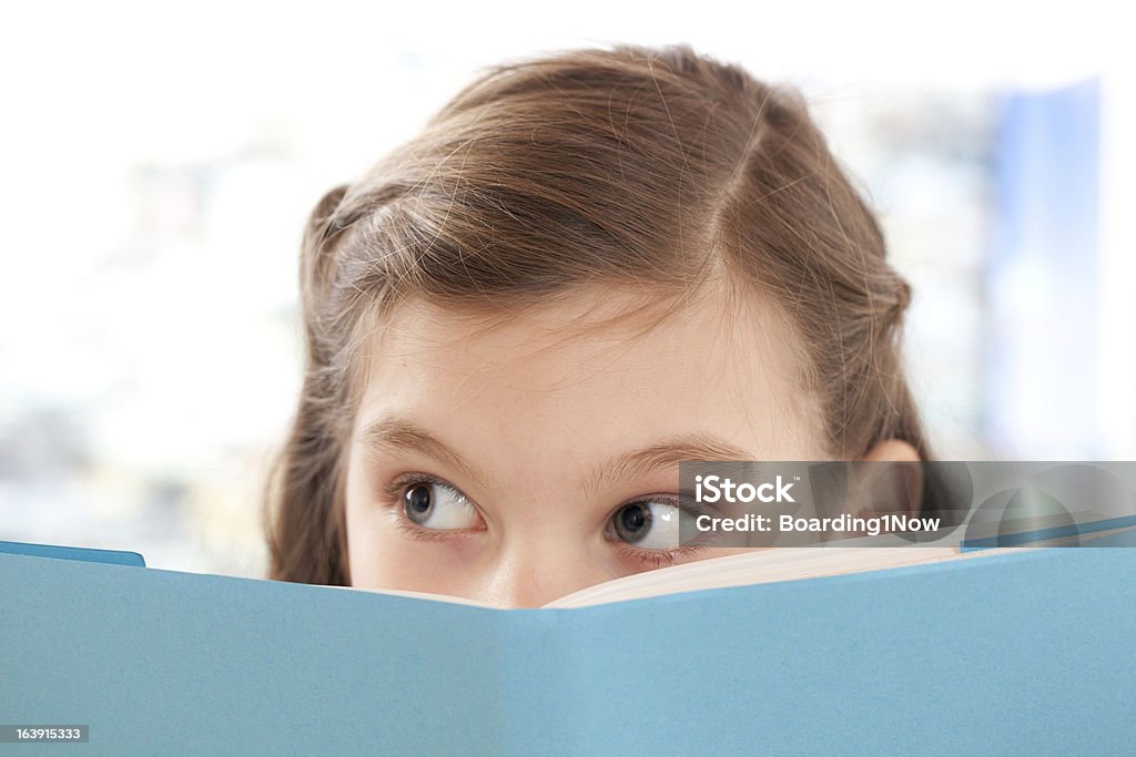 Niña leyendo un libro escolar - Foto de stock de Conceptos libre de derechos