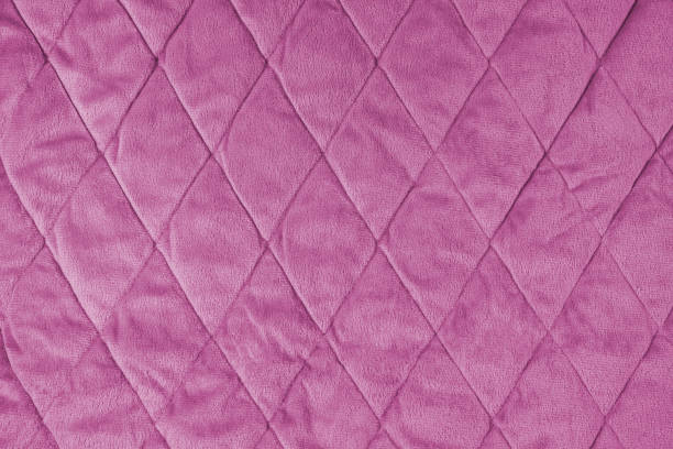 Cтоковое фото Стеганый фон из розовой велюровой ткани, мятая мягкая поверхность одеяла