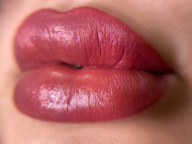 istock permanent womans lips tattoo close up, lipstick effect make up, the lips after a tattoo with a coloring pigment 1639188063