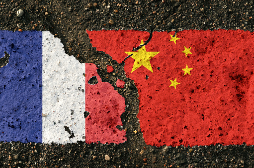 On the pavement are images of the flags of France and China, as a symbol of confrontation. Conceptual image.