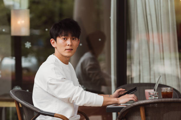 istock Young man at coffee shop using mobile phone 1639245222