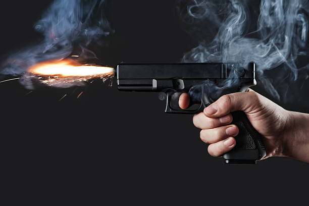 Handgun firing with fire and smoke stock photo