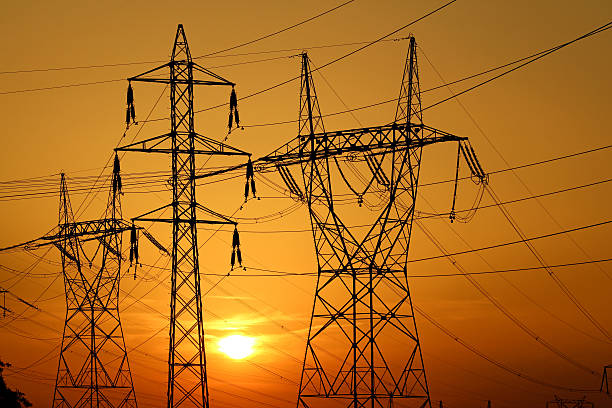 istock group of high voltage pole against sun 163928152