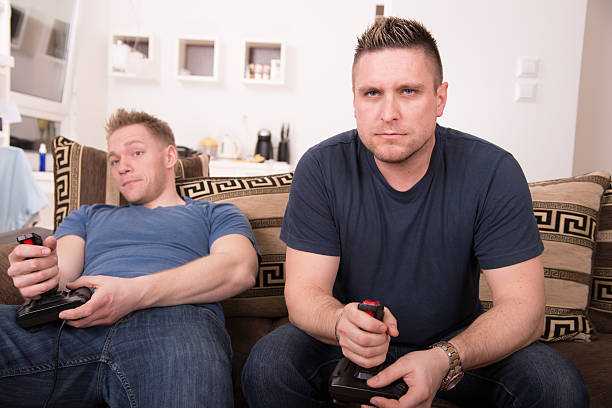 istock Guys playing video games on couch 163928172