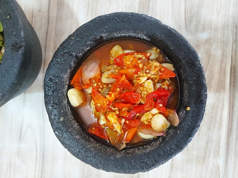 Sambal bawang. It is indonesian traditional chili sauce. Made from red cayenne pepper,red tomato, garlic, shallot, salt, sugar, flavoring. Served on traditional stone container
