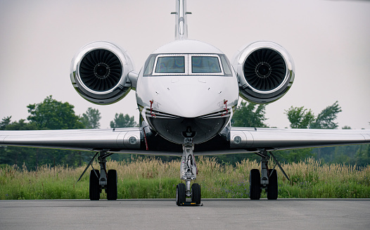 A medium-sized jet parked at a small regional airport. The engines, wings and fuselage are visible.