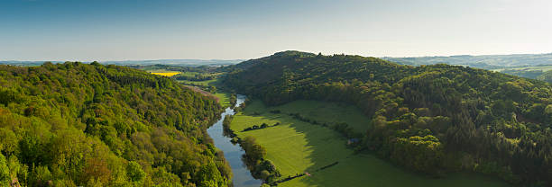 Idyllic rural Meandering River Wye making its way through lush green rural farmland in the warm early sunlight. Stitched panoramic image detailed when viewed large. patchwork landscape stock pictures, royalty-free photos & images