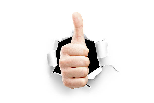 istock Thumb up through a hole in paper 163930890