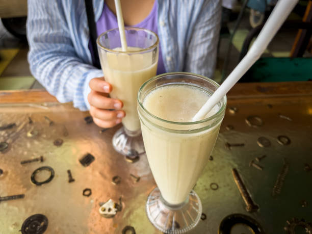 Multiracial Young Woman Drinking Soursop Juice in Balinese Cafe, Indonesia stock photo