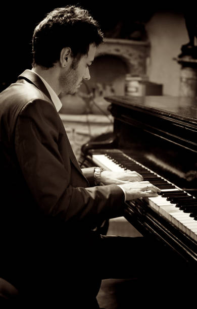 istock Young man in suit playing piano. Black and white 163942743