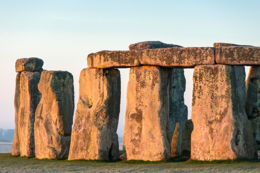 The very first light of the day hitting the iconic Stonehenge on Salisbury Plain, Wiltshire, England, UK.