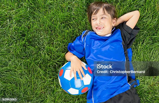 Foto de Menina Tomando Uma Pausa De Futebol e mais fotos de stock de Criança - Criança, Deitar, Grama