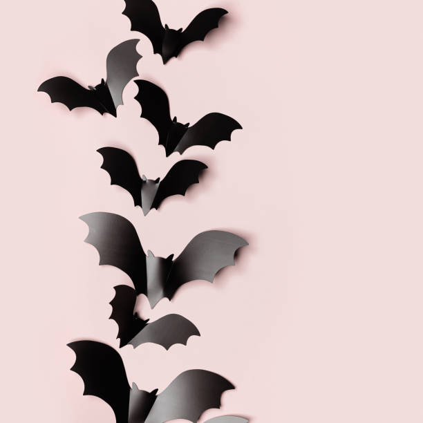 istock Black bats and soft shadow as halloween party background with empty space. Frame from paper decorations flying bats on pastel pink background for holiday card or invitation. Top view halloween 1639433162