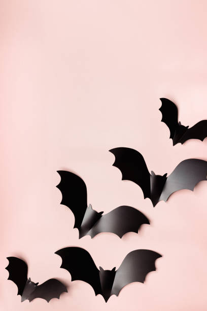 istock Minimal flat lay with black bats as halloween party background. Frame from paper decorations flying bats on beige background for holiday card. Aesthetic halloween pattern, copy space 1639433315