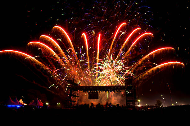 Vivid Red Fireworks Over Stage of New Year's Eve Concert stock photo