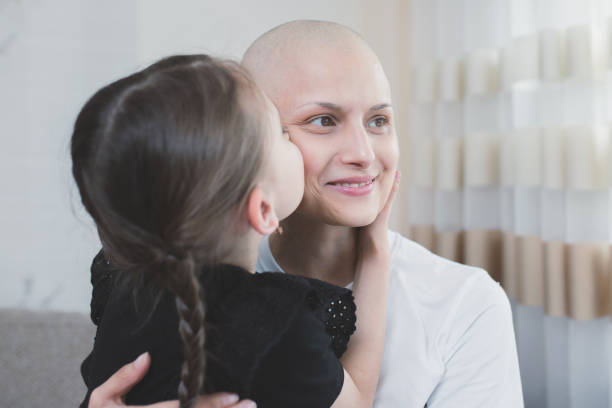 donna sorridente con oncologia che trascorre del tempo con il suo bambino a casa. cancro e concetto di sostegno alla famiglia - cancer chemotherapy drug baby family foto e immagini stock