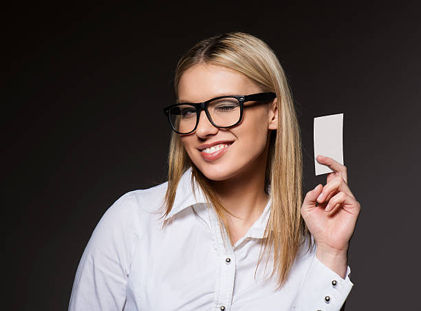 sorridente mulher de negócios com um cartão em branco - glasses holding business card imagens e fotografias de stock