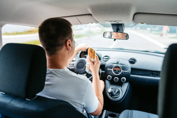 istock Young Man Eating A Sandwich While Driving A Car 1639627914